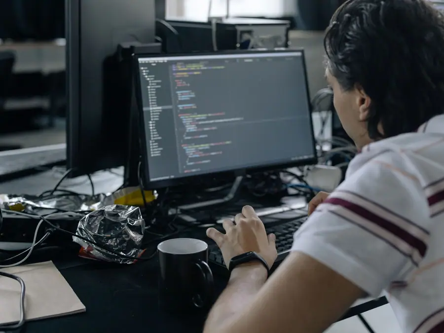 Persona programando frente a una computadora